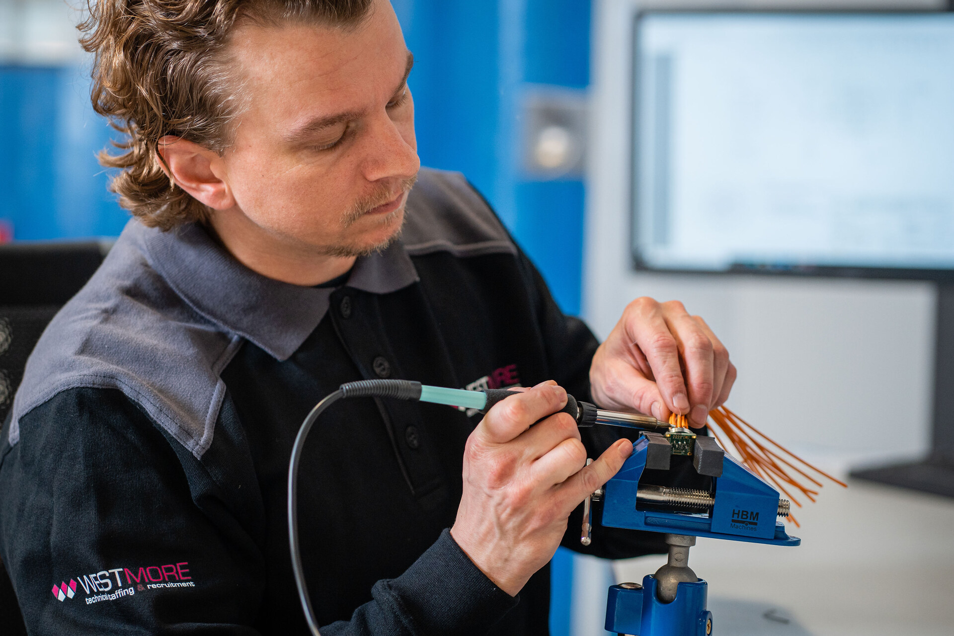Westmore – Elektronicamonteur soldeert printplaat – close-up